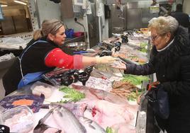 Cristina Insausti cobra a una clienta en su pescadería en el exterior del Mercado de San Blas de Logroño.