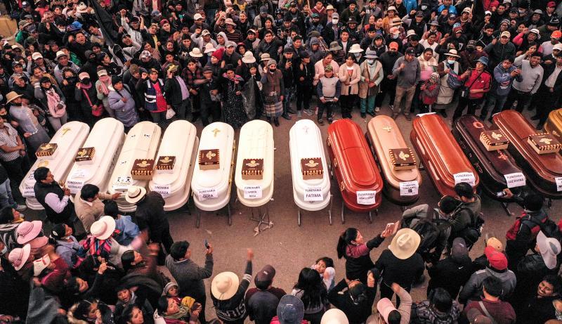 Los ataúdes alineados esperan en el hospital Carlos Monge a que sean entregados los cadáveres de los muertos en la masacre del lunes en Juliaca.