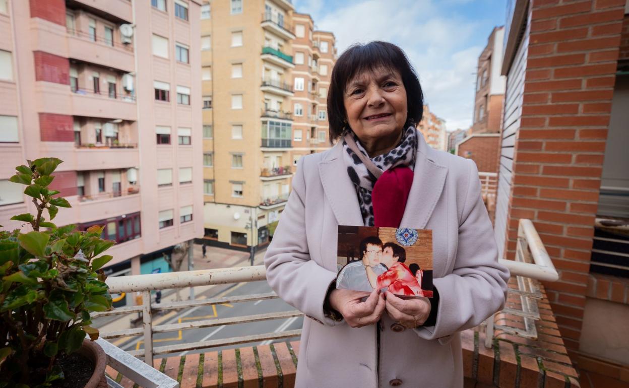 Nieves Pombo, en el balcón de su casa, en Logroño, con una foto de su hijo en las manos. 