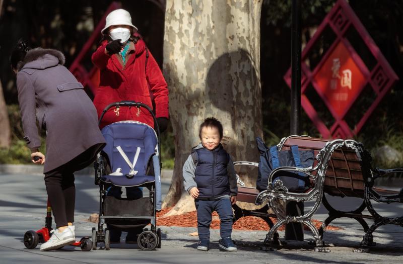 Una mujer pasea con sus dos hijos en un parque de Shánghai tras el levantamiento este mes de las restricciones sanitarias