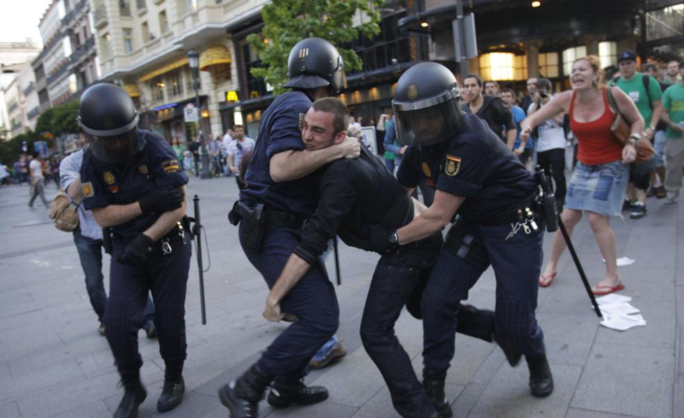 Policías antidisturbios detienen a dos estudiantes, en Madrid, durante una jornada de protesta contra los recortes en educación