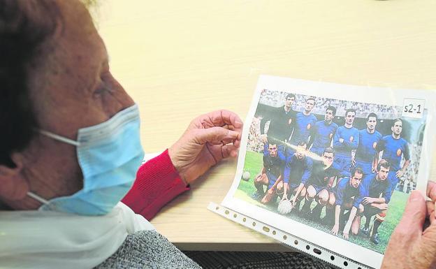 Una de las participantes en el taller observa una fotografía en la que aparecen jugadores como Iríbar, Zoco, Marcelino, Luis Suárez o Lapetra. 