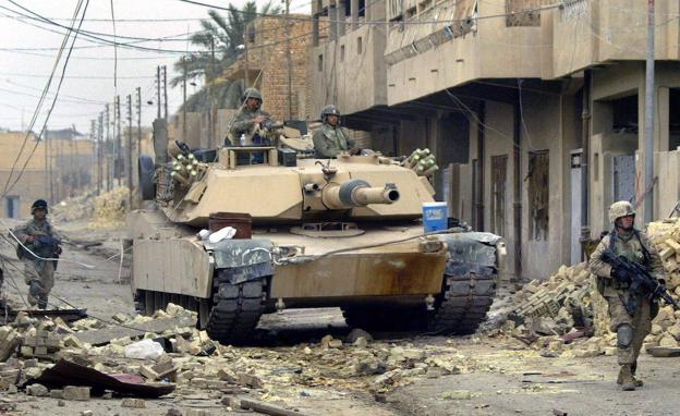 Imagen principal - Arriba, un Abrams avanza por las calles de Irak con la protección de unidades de infantería. Abajo, una imagen del manual de los Marines para proteger los tanques y un Leopard polaco.