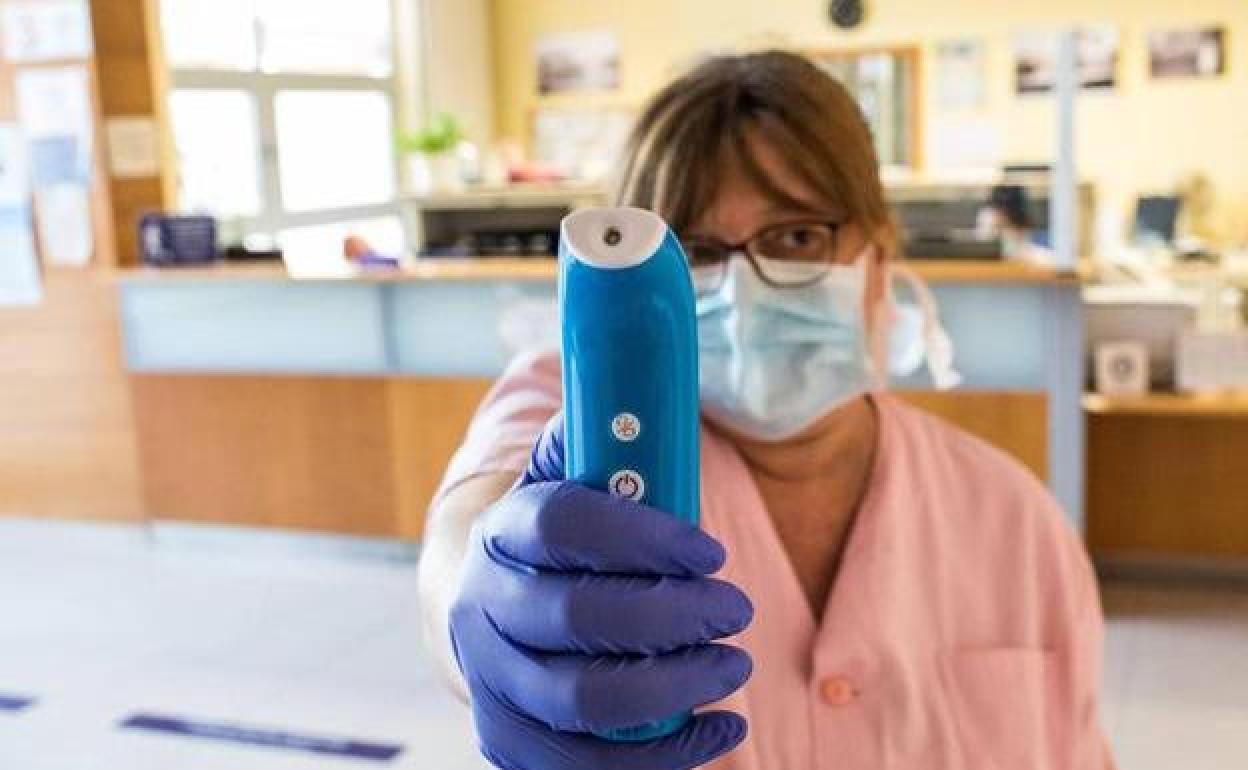 Una enfermera toma la temperatura en un centro de salud.