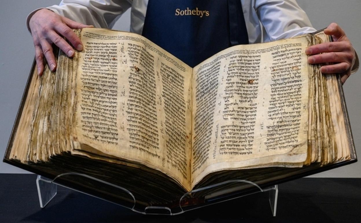 Un operario de Sotheby's muestra la milenaria Biblia hebrea que se subasta el 16 de mayo en Nueva York.