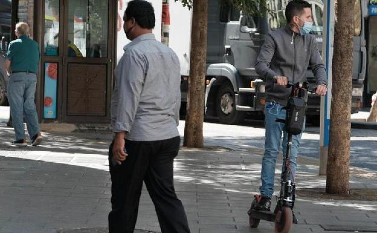 Un patinete circula por la acera.