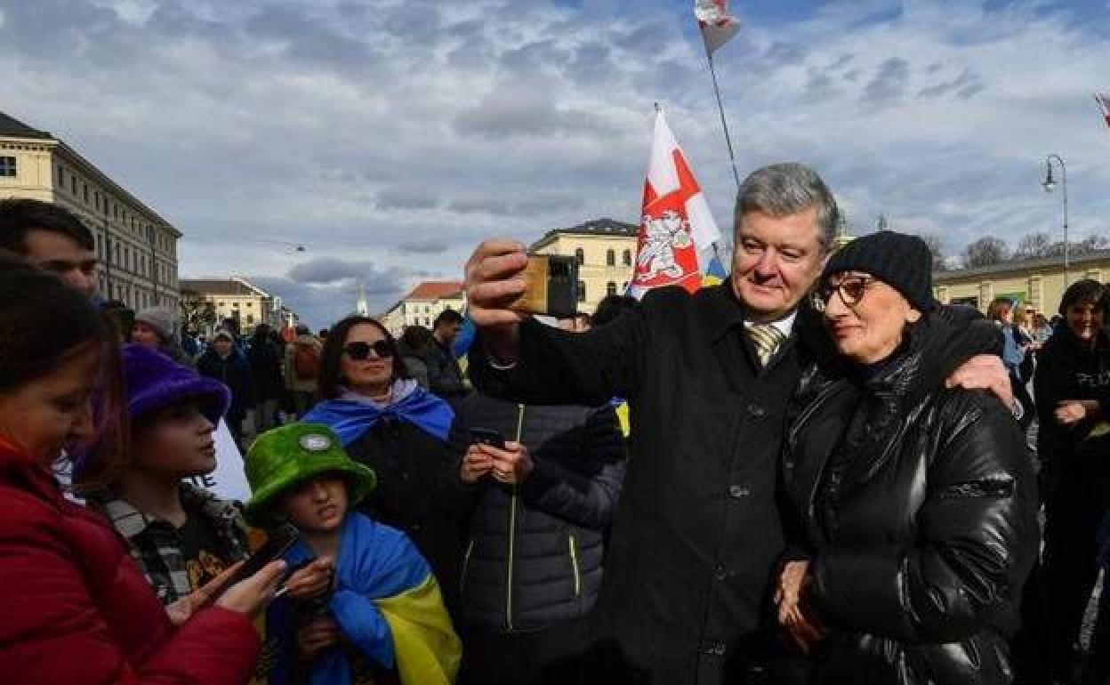 El expresidente ucraniano Petro Poroshenko se fotografía con una admiradora en la cumbre de Múnich.