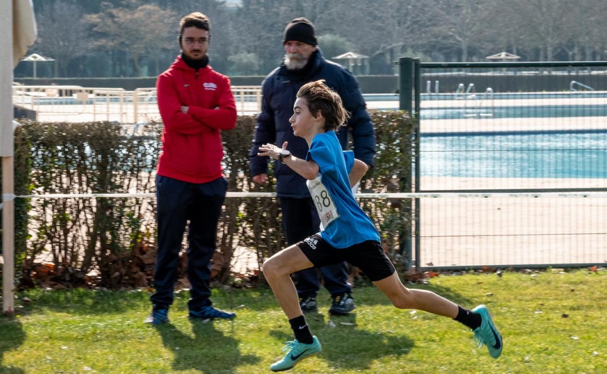 Un fondista esprinta en los últimos metros, observado por dos jueces. 