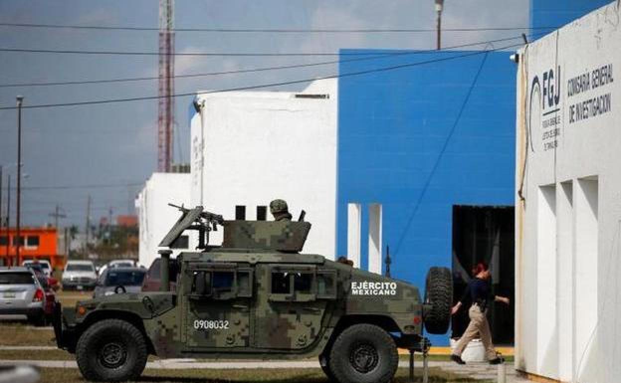 Un vehículo militar vigila la sede del instituto forense donde se depositaron los cadáveres.