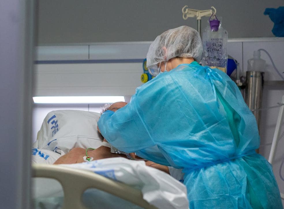 Una enfermera atiende a un paciente ingresado en la UCI por covid. 