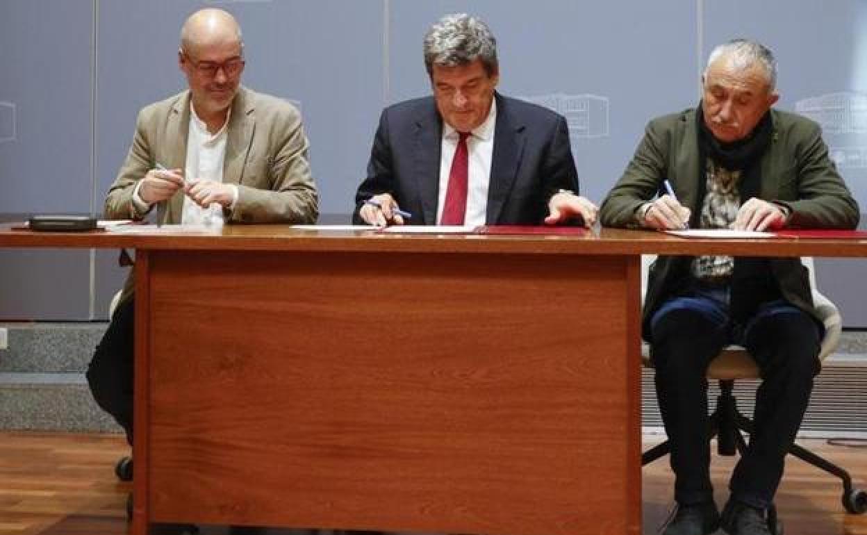 El ministro José Luis Escrivá (centro), y los secretario generales de CC OO y UGT, Unai Sordo (i) y Pepe Álvarez (d), durante la firma del acuerdo.