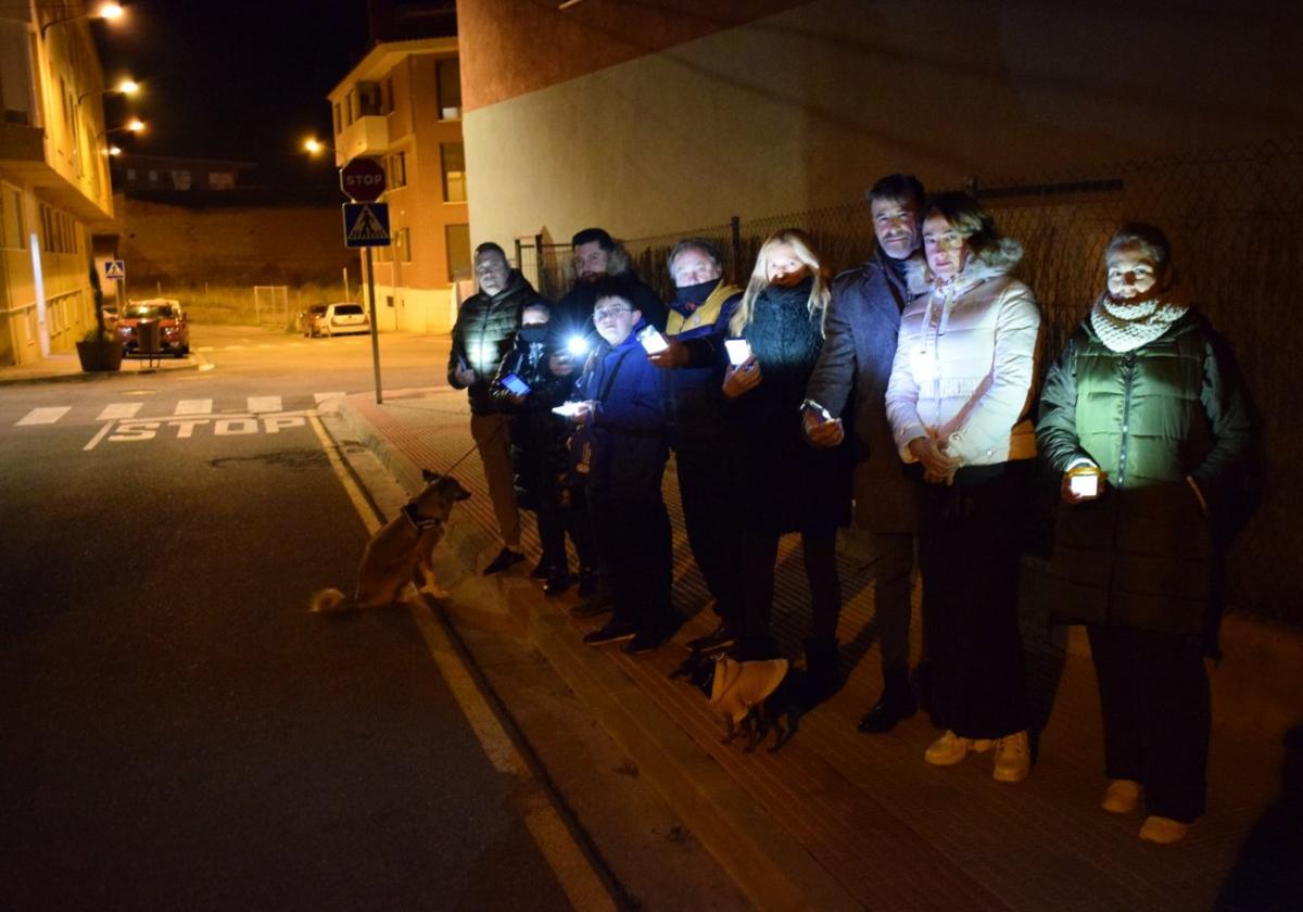 Vecinos del entorno de la ermita de Santa Eufemia de Villamediana de Iregua se iluminan con sus propios teléfonos en un tramo sin iluminación de la calle Río Glera.