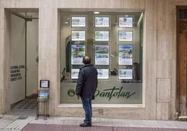 Un hombre mira el cartel de una inmobiliaria en Baleares.