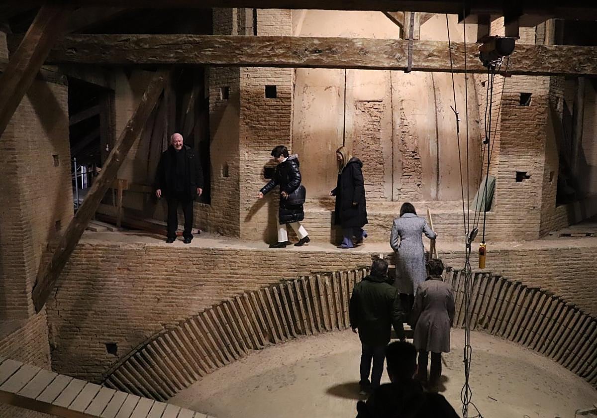 El párroco Carlos Esteban guía, hace unos días, a la alcaldesa y a la presidenta del Parlamento por el pasillo alrededor de la bóveda central.