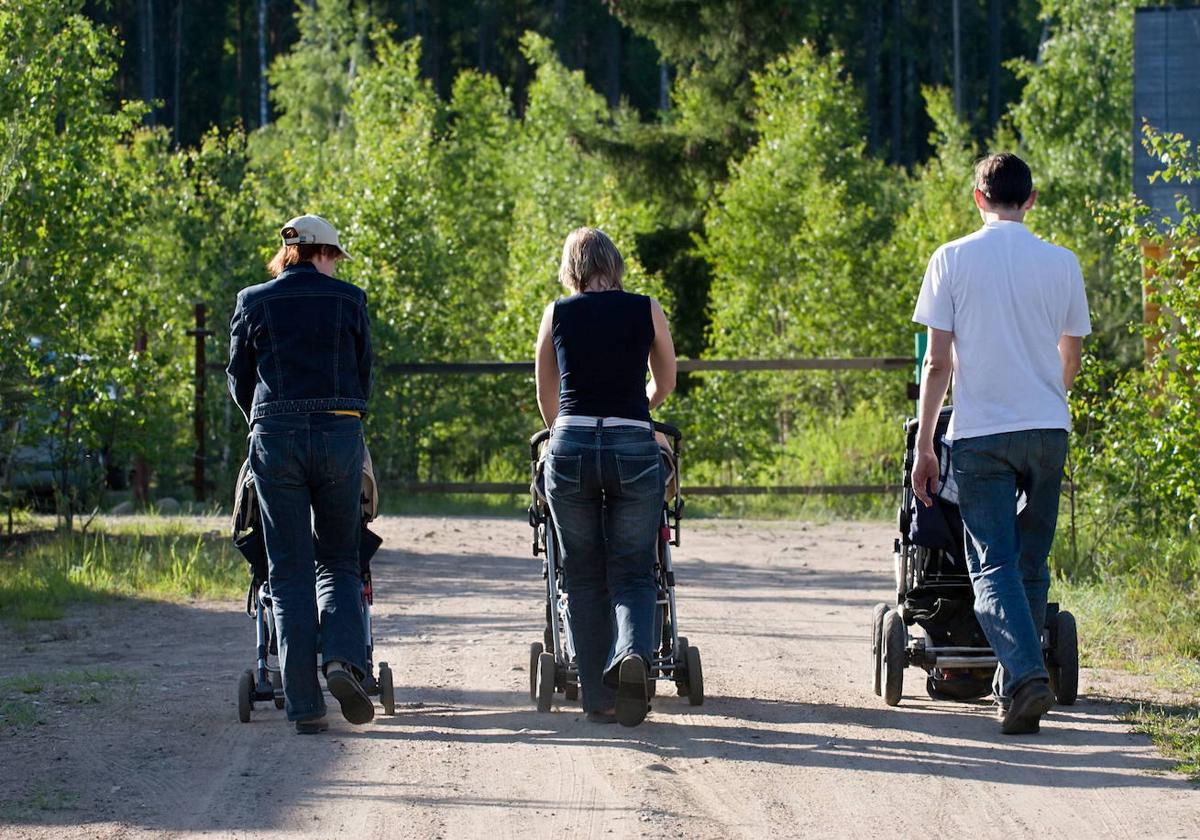 Dos madres y un padre pasean con sus niños.