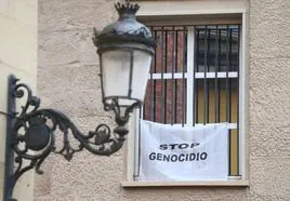 Pancarta colgada en la ventana del Parlamento de las dependencias de Podemos-IU |