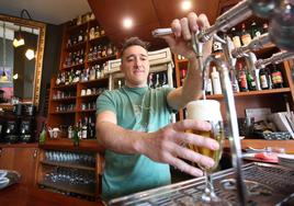 Óscar Maroto, propietario del Café Delicias, sirve una cerveza a un cliente.