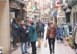 Vecinos, comerciantes y representantes municipales conversan cerca de uno de los puestos instalados en la calle Mayor de la localidad.