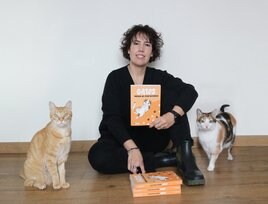 Celia Alesanco posa con su libro 'Gatos. Manual de instrucciones' junto a sus mascotas felinas Link y Zelda.