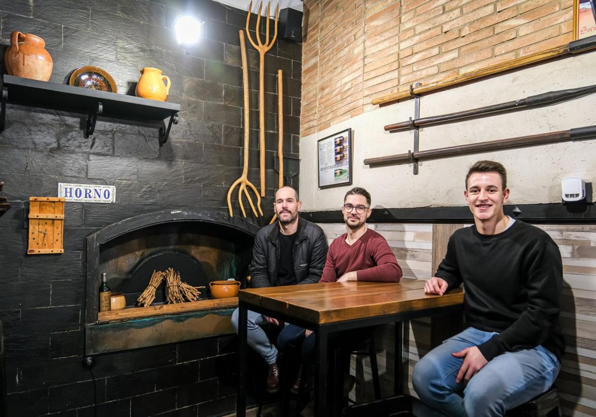 Arriba, fachada de La Chata; debajo, los tres jóvenes que se han hecho cargo de la reapertura del restaurante.