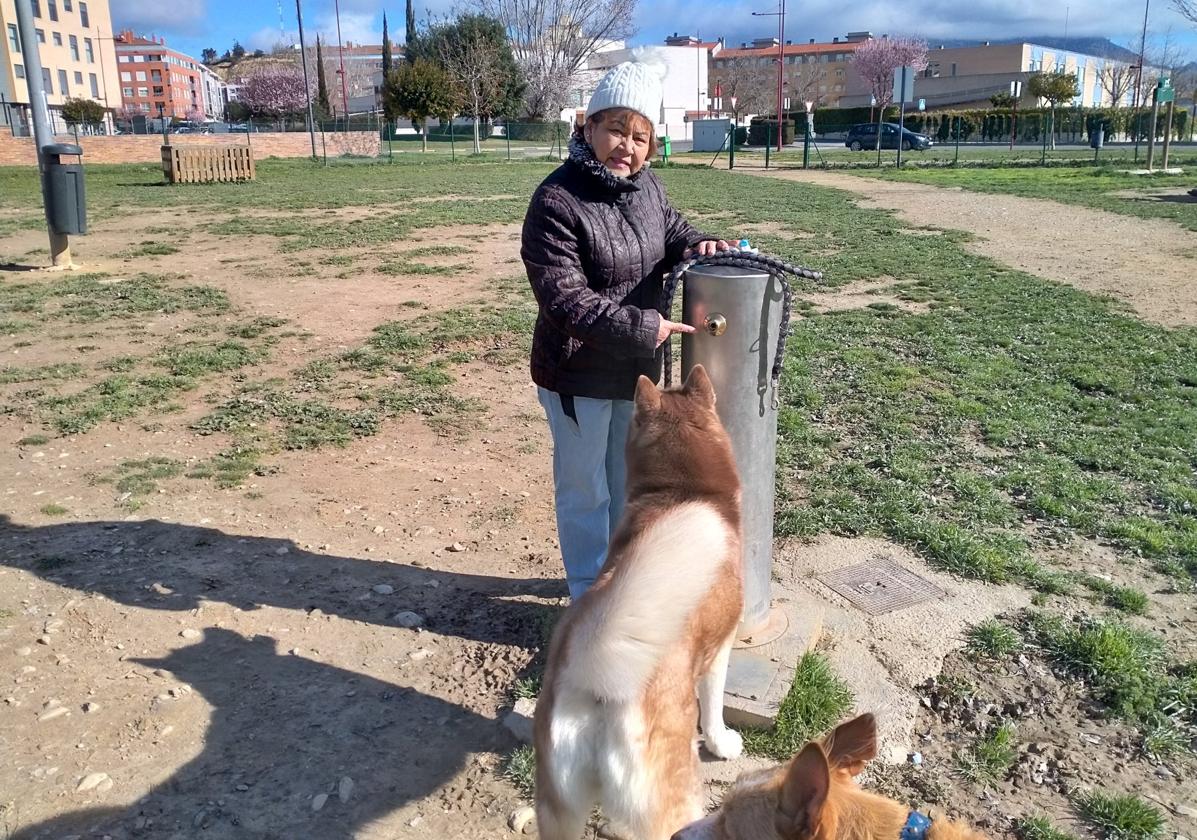 María Pin en la fuente de la zona de esparcimiento canino, con su perra Cuca. A la derecha, puertas de Santa Lucía, Eliseo Pinedo y Juan Carlos I.