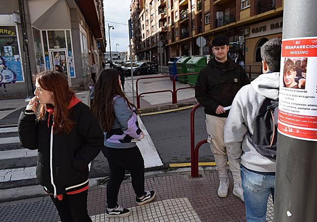 Unos jóvenes de Santo Domingo colocan carteles de la desaparición de Javier Márquez en Logroño.