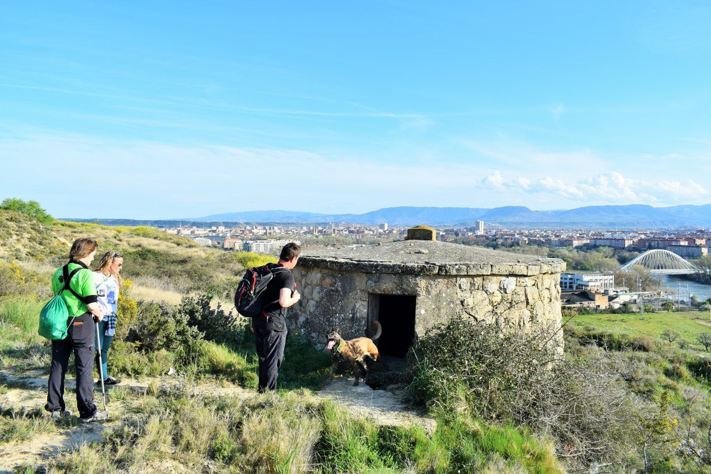 La perra Argui sale de un depósito de agua abandonado del monte El Corvo, guiada por Francisco José Caparroso, ante la atenta mirada de Noelia Pascual y María Jesús Moreno.