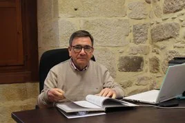 García Sáez, en su despacho del Monasterio, con el libro que resume la historia del Patronato.