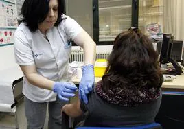 Una enfermera vacuna a una mujer embarazada en un centro de salud.