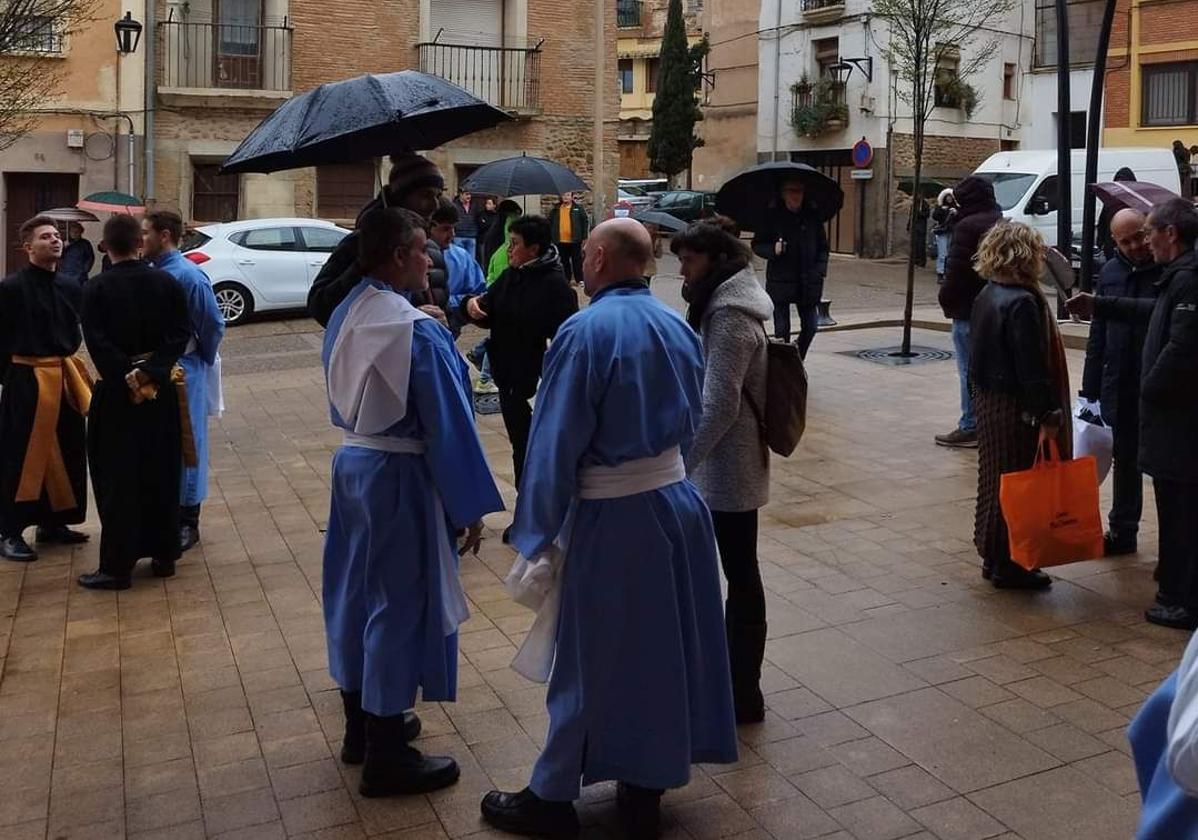 Los cofrades del paso de La Piedad y el Cristo de la Vera Cruz en la parroquia de San Andrés, a la espera de que deje de llover