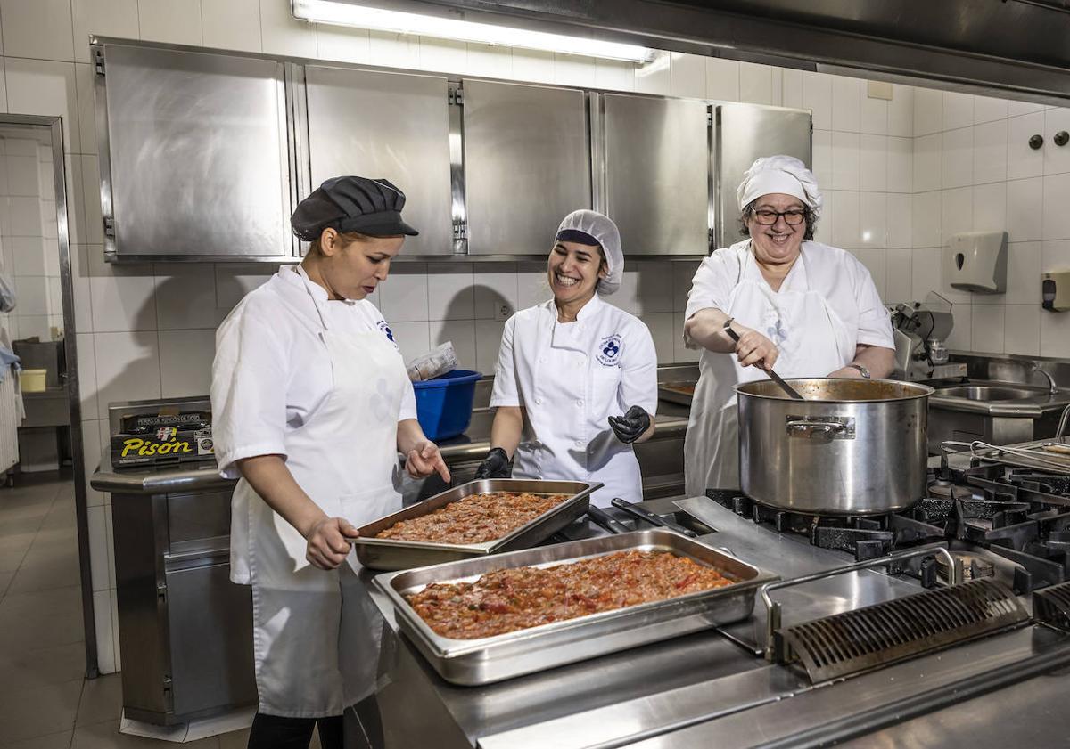 Imagen principal - Empleados y voluntarios de la Cocina Económica desarrollan su labor.