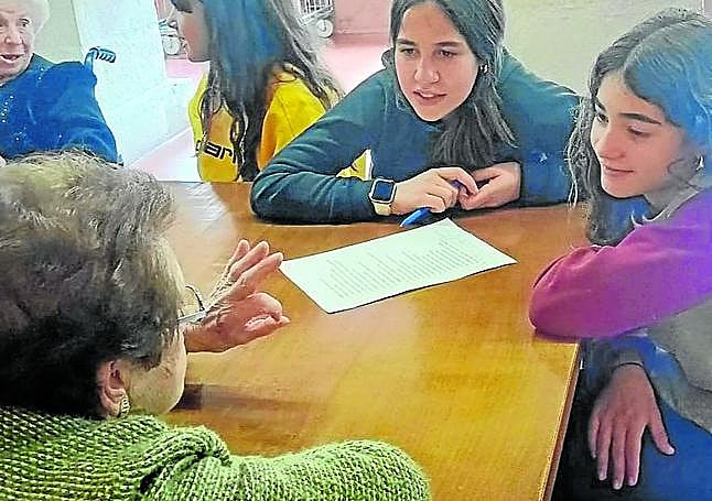 Dos jóvenes siguen la explicación de una mujer.