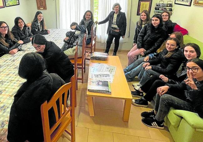 Un grupo de jóvenes en el comedor del albergue, escuchando a Mercedes Pascual.