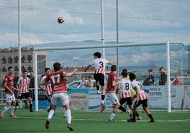 Pugna por el esférico tras un saque desde la esquina durante el partido entre la UD Logroñés B y Alfaro.