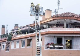 Los bomberos trabajan en el ático que quedó destrozado tras una explosión.