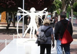 Dos ciudadanos ante la maqueta del Hombre de Vitruvio, una de las piezas de la exposición 'Leonardo Da Vinci' en el parque Gallarza de Logroño.