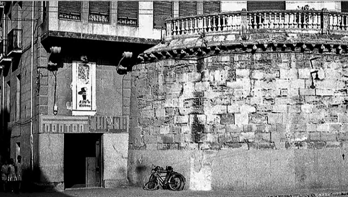 Imagen principal - Imágenes en blanco y negro expuestas en el propio complejo a día de hoy, siendo entonces el 'Cinema Frontón' (con la colocación de una balaustrada en los años 30 como parte de la terraza), y la Puerta del Camino (o de Carlos V) anexa tapiada; y ya en color, parte de los nuevos contenidos con que se actualizó el conjunto de cara al V Centenario del Sitio de 2021.