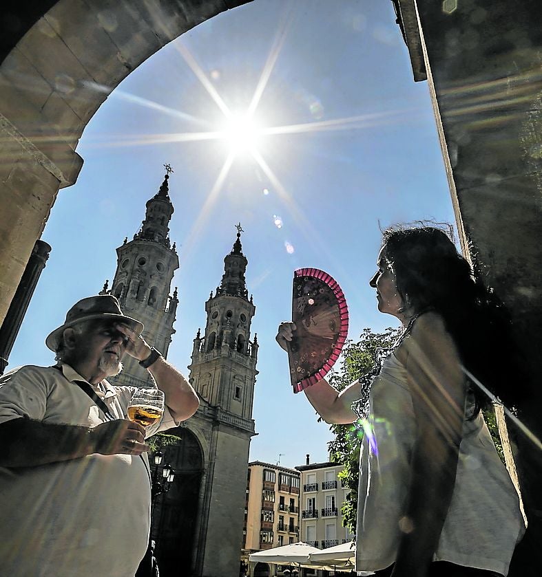 Una pareja trata de refrescarse en los soportales de la logroñesa plaza del Mercado, en una tórrida jornada de agosto del pasado año.