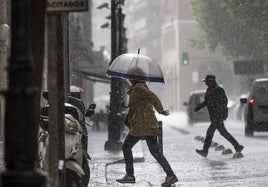 Una ciudadana se protege de una de las tormentas registradas el pasado mes de mayo.