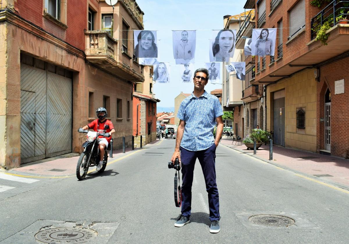 Félix Guerra posa con su cámara en la avenida de Cameros de Villamediana, bajo su exposición 'La pared blanca'.