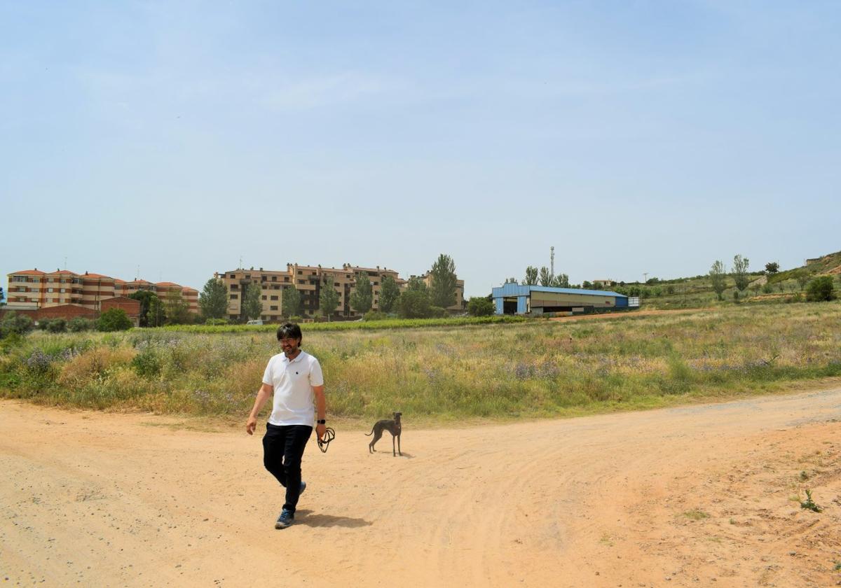 Pablo Villar pasea a su perro por el camino de la Solana, junto al terreno, antes un viñedo, donde se ha proyectado el campo de fútbol.