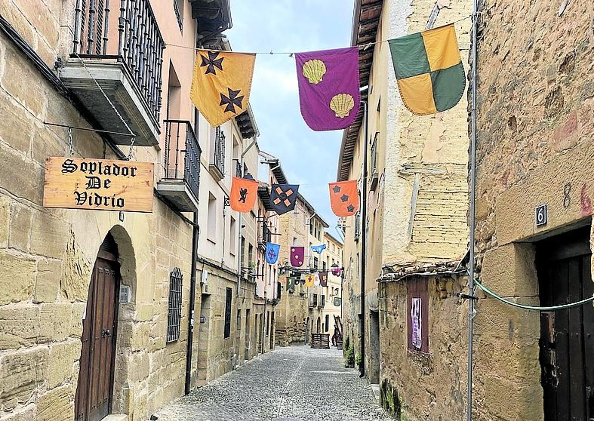 Imagen secundaria 1 - Una de las calles ornamentada con banderolas (izq.). Dos jóvenes preparan el papel para el portal de 'Papel Trapo'. 