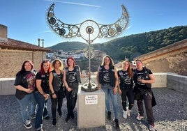 Las integrantes de la asociación Aquelarre posan con el nuevo monumento, con Ortigosa al fondo.