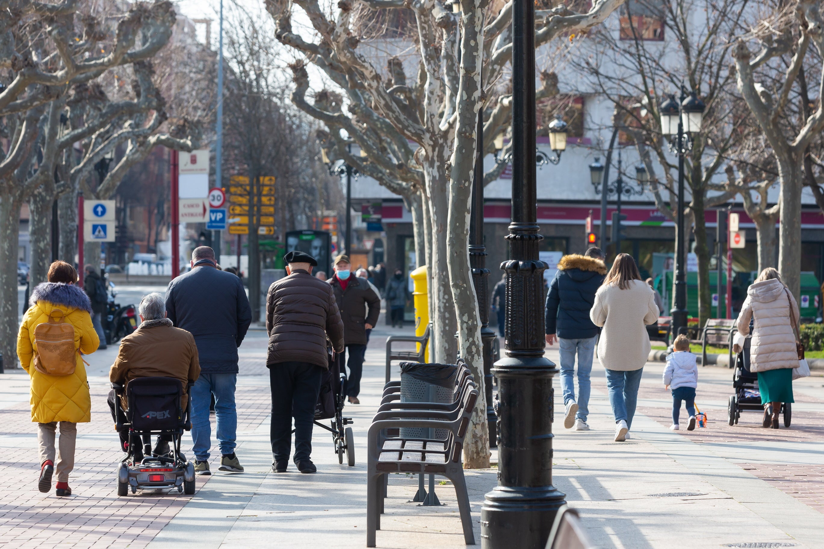 Personas mayores y familias con niños, de paseo por el Espolón, en Logroño.