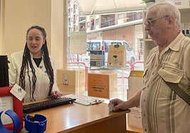 Una trabajadora de la farmacia Palacios atiende a un cliente.