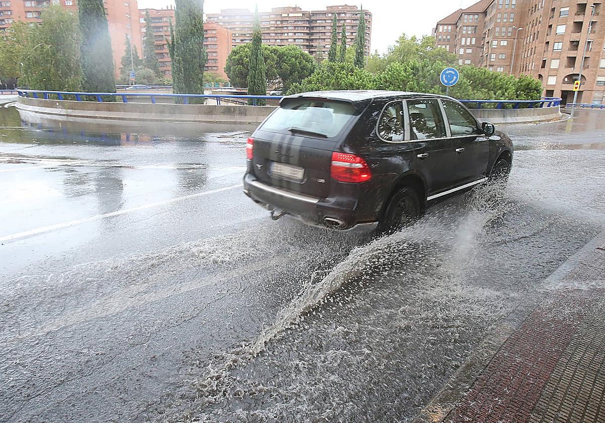 Un coche circula por el centro de Logroño en un día de tormenta.
