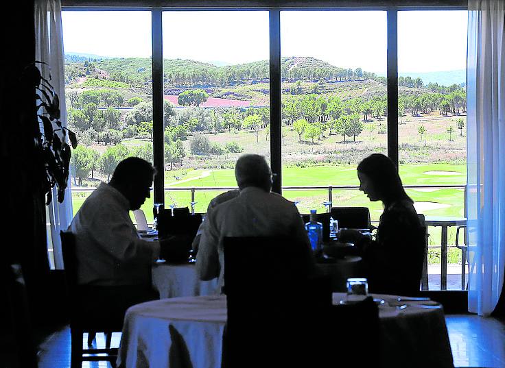 Unos comensales, en el salón de Divot con vistas a La Grajera.