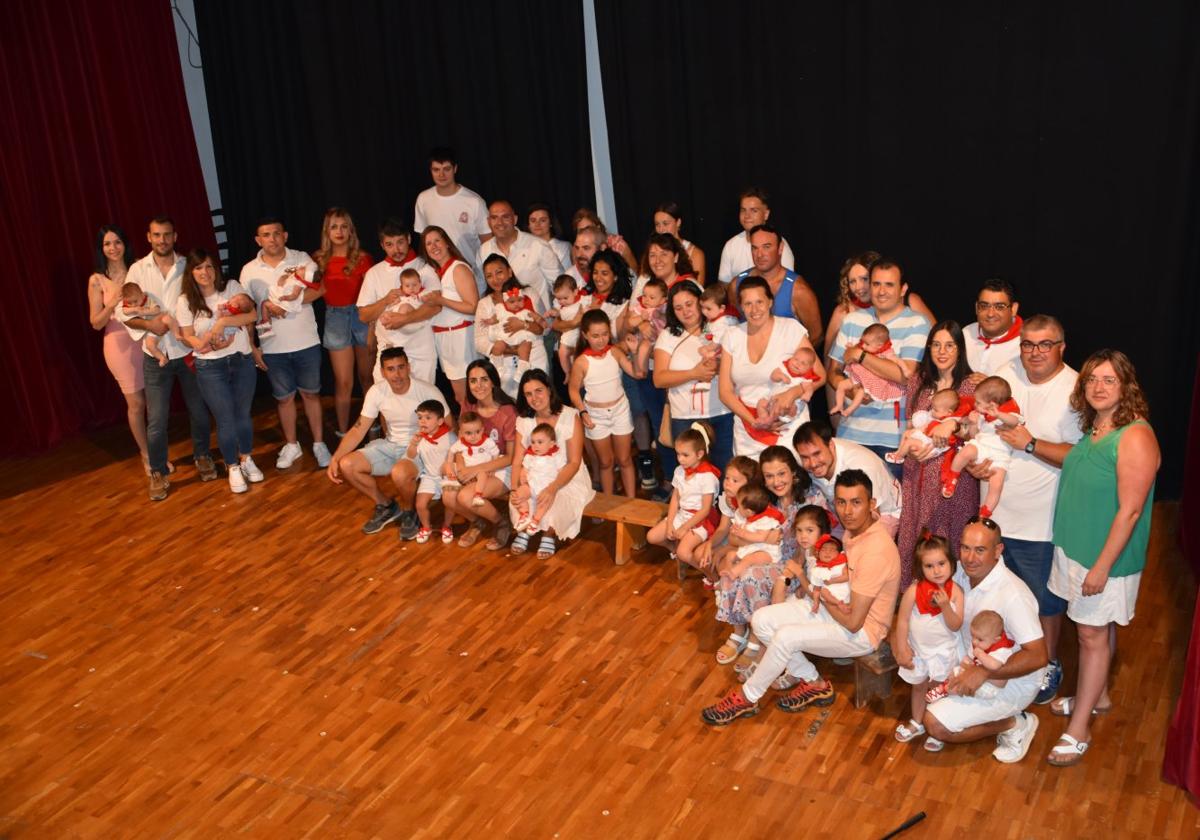 Participantes en la imposición de pañuelos a 21 niños nacidos en el último año y, a la derecha, un momento del recorrido del '¡Agua va!'.