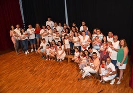 Participantes en la imposición de pañuelos a 21 niños nacidos en el último año y, a la derecha, un momento del recorrido del '¡Agua va!'.