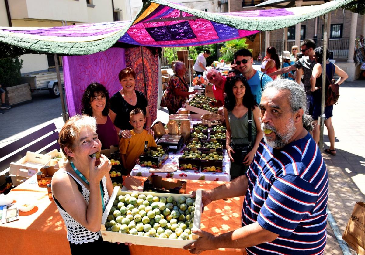 Fabi y Alejandro prueban ciruelas reina Claudia en el puesto de venta de la plaza de la Tela.